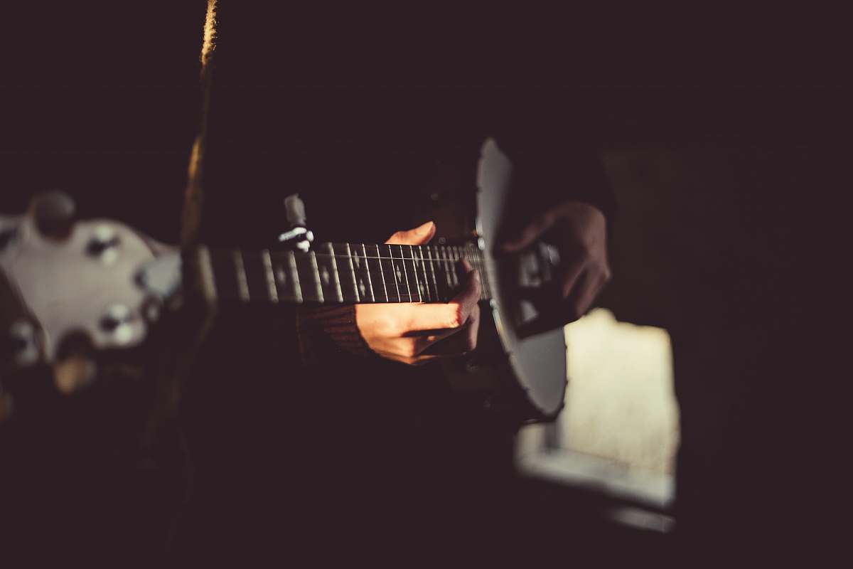 musical instrument person playing banjo inside dark room guitar